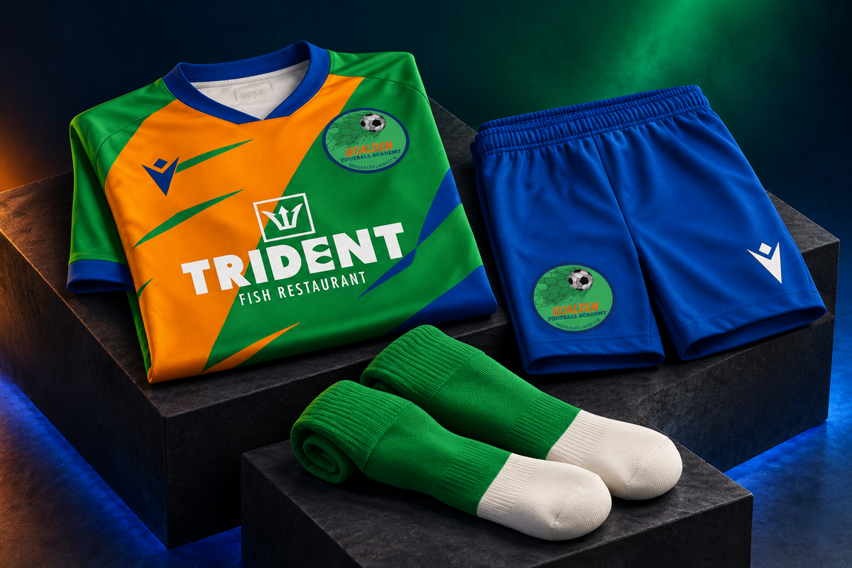 Goalden shirt, shorts and socks neatly folded on dark studio display plinths