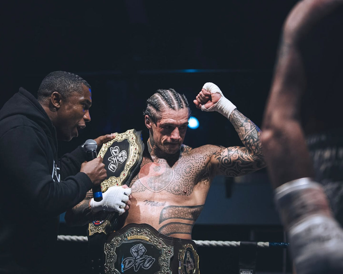 Marlon Gillett holding his championship belts after a fight